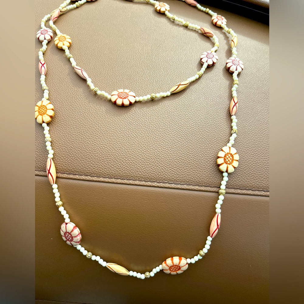 The cutest flower necklace! I believe it's plastic. Super long
